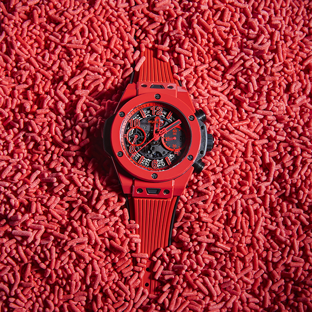 Red Hublot watch placed within red candy sprinkles 